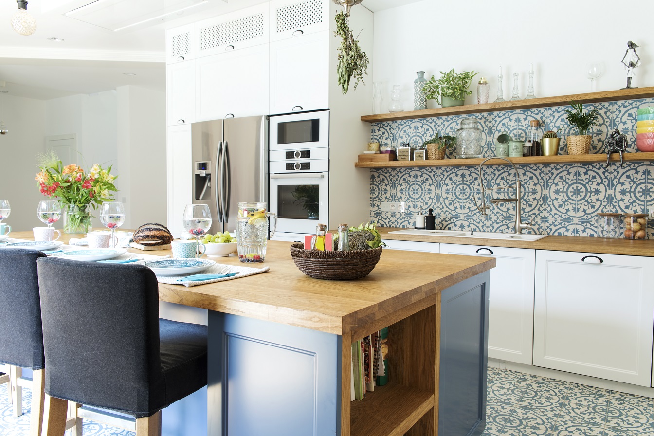 Stylish kitchen interior with accessories, wooden table and plants.